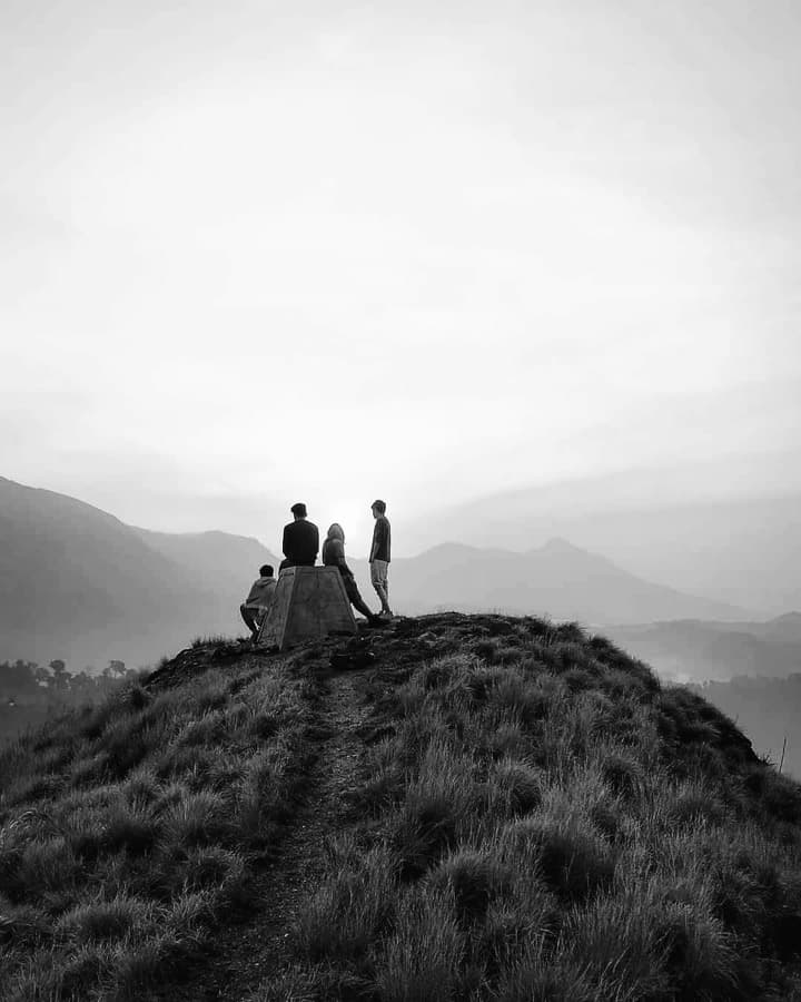 Friends standing together on a misty mountaintop